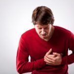 Young man with strong chest pain, horizontal